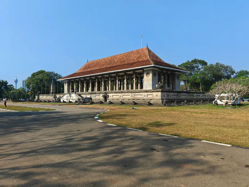 A columned monument with an orange tiled roof beneath blue sky