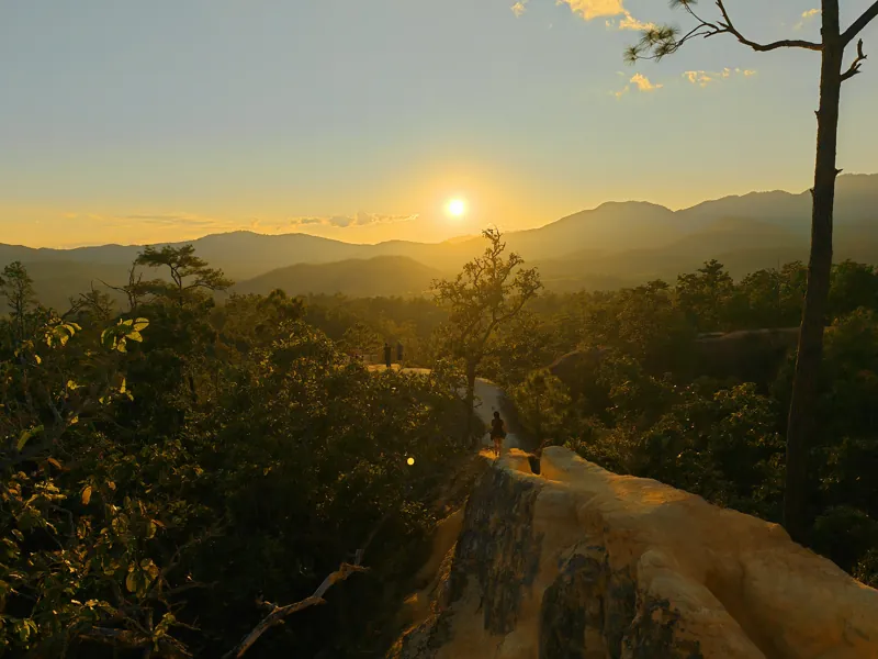 Golden sunset over layers of mountains and a wooded valley