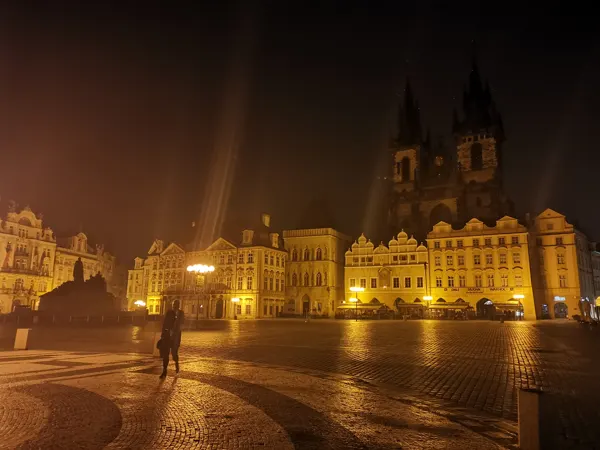 An illuminated Prague square on a quiet evening