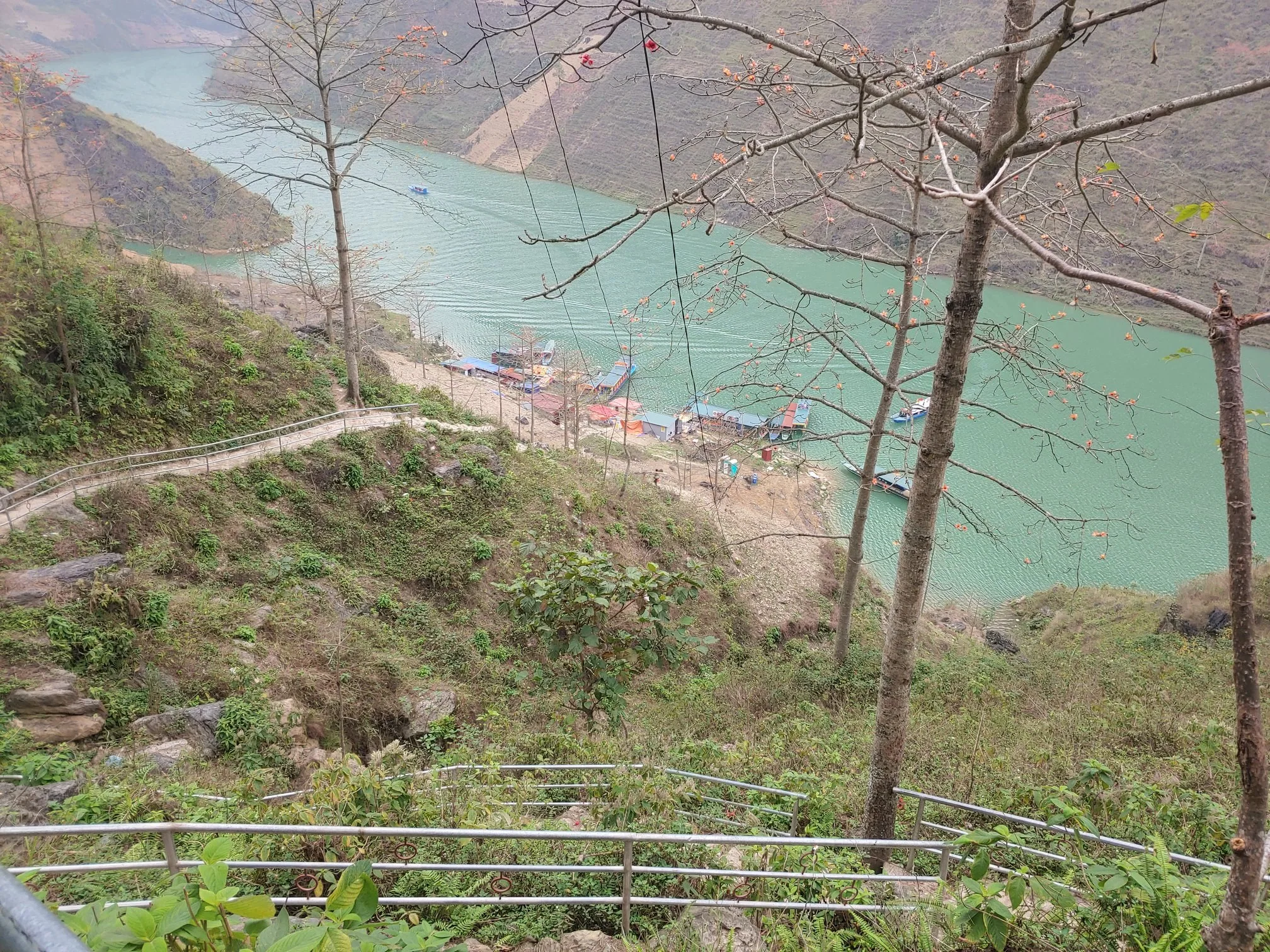 A turquoise river below a mountain road in northern Vietnam