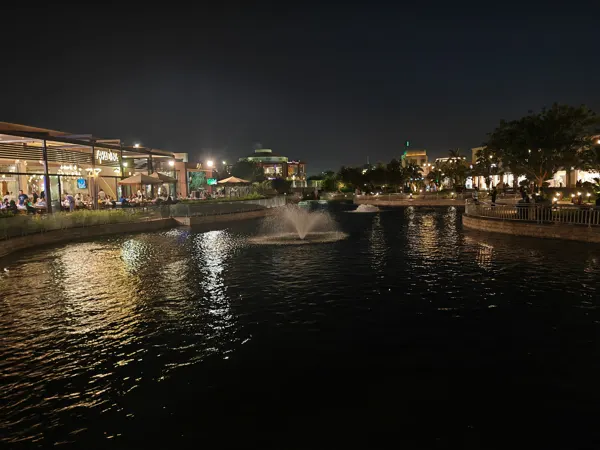 Fountains and restaurants reflected in water after dark in Cairo