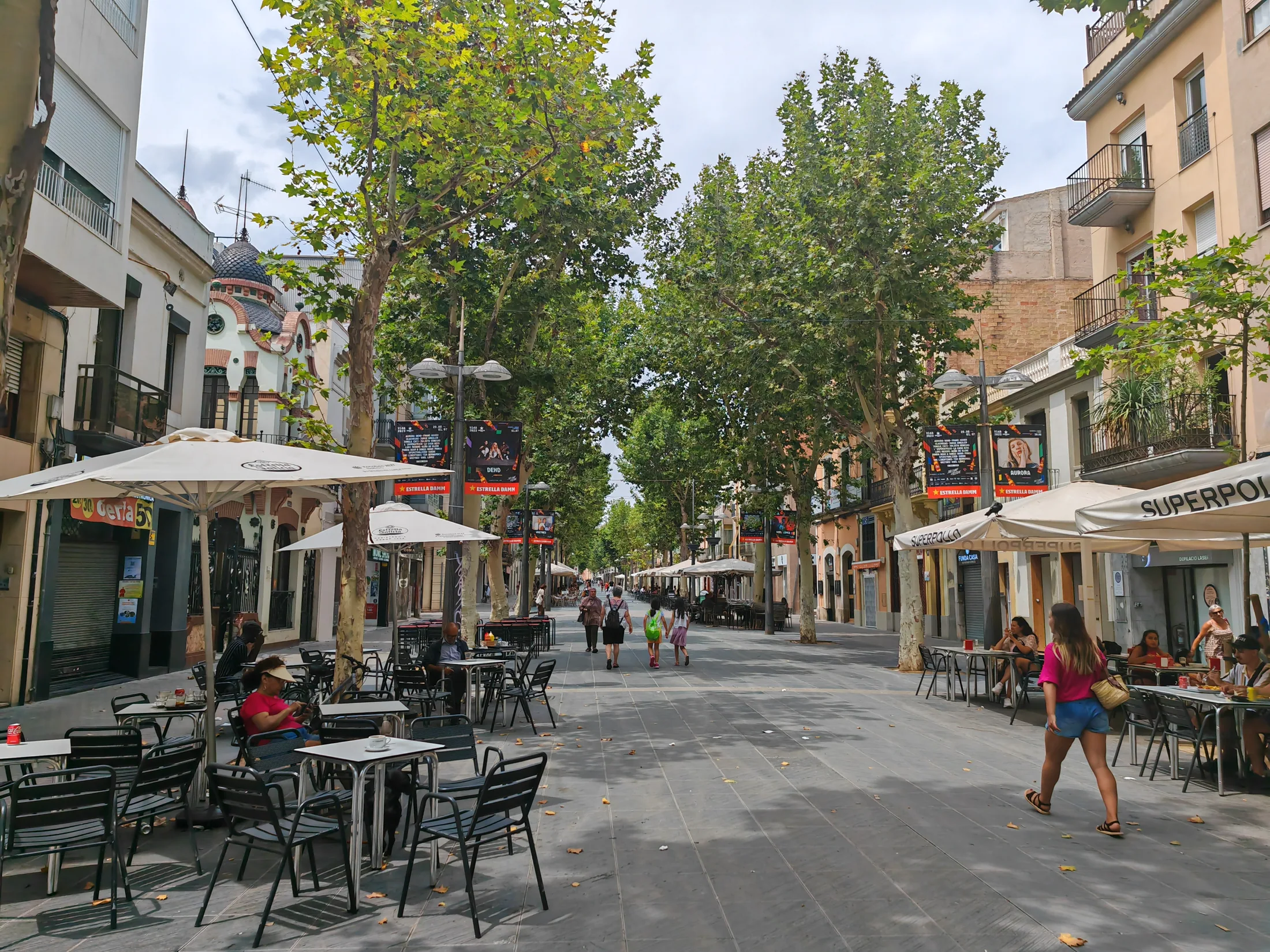 Café tables along a tree-lined street in Barcelona
