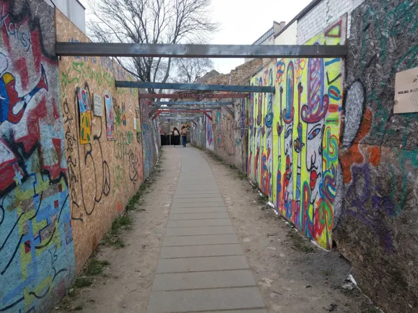 A narrow walkway lined with colourful street art