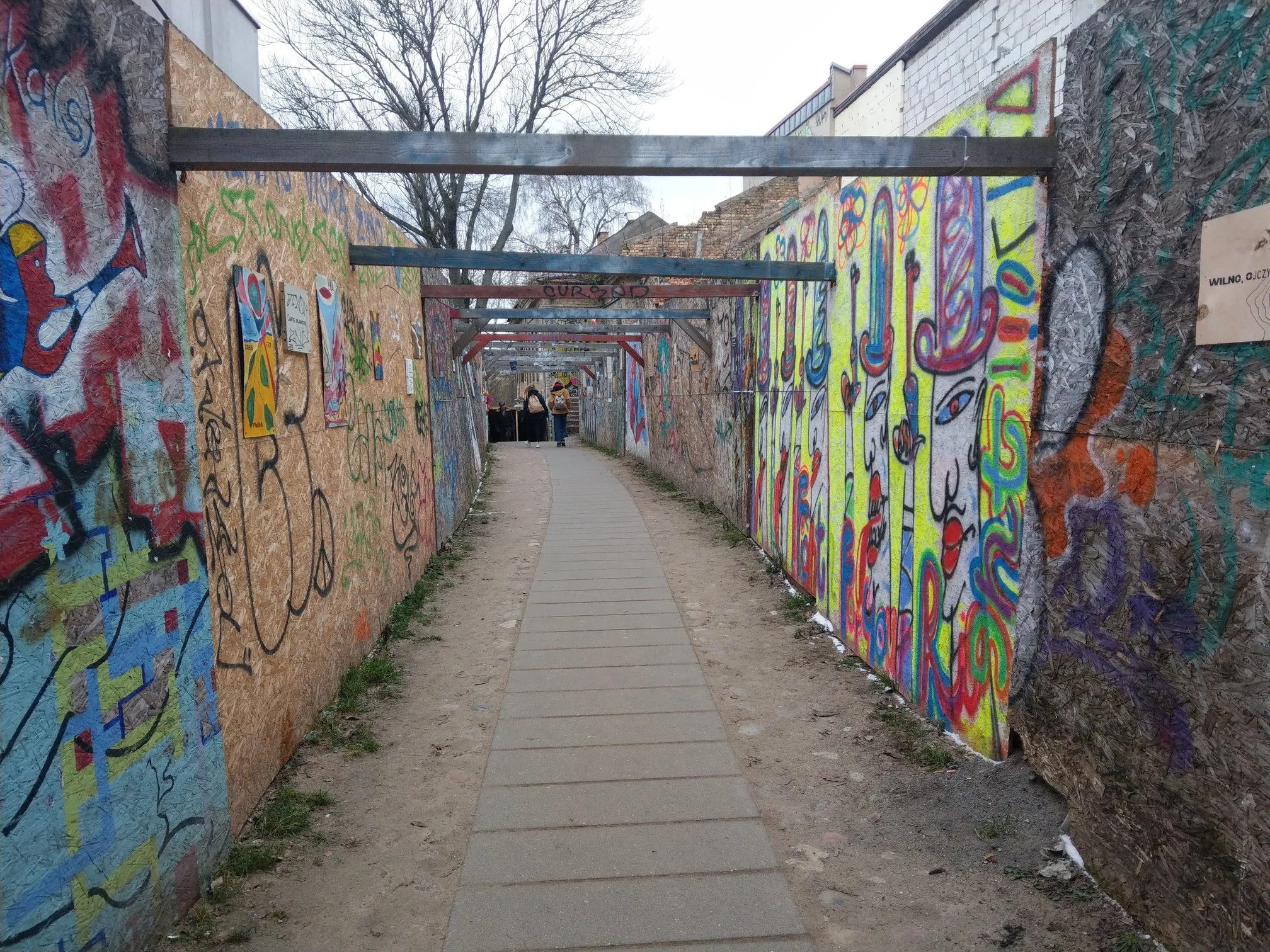 A narrow walkway lined with colourful street art
