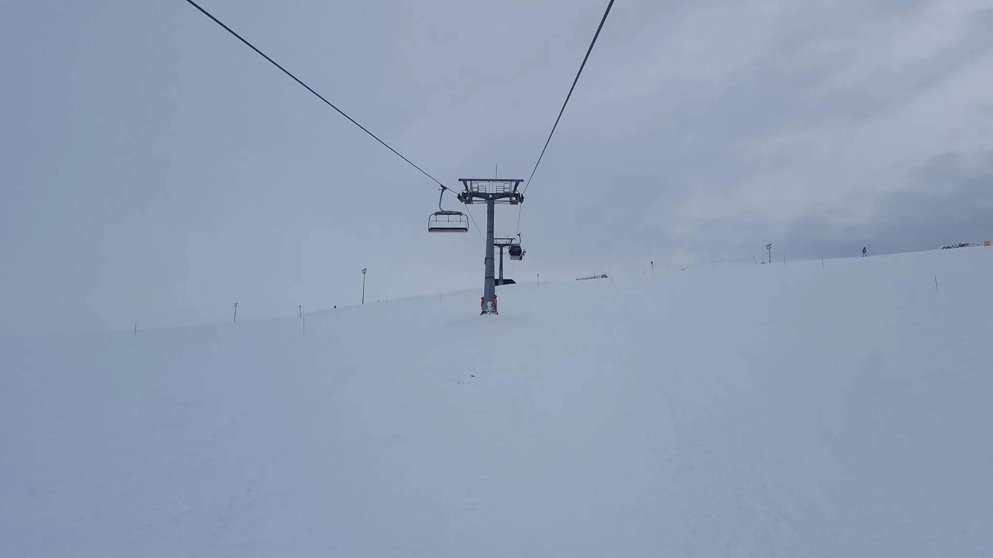 A ski lift disappearing into a snow-covered slope