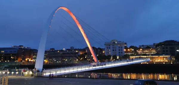 The Gateshead Millennium Bridge glowing over the Tyne after dark