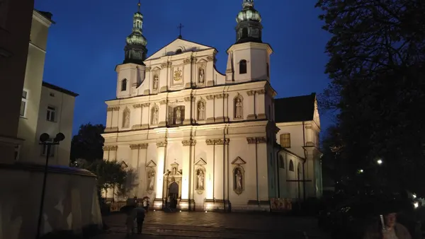 An illuminated church façade against the evening sky