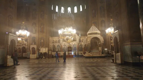 Chandeliers illuminating a richly decorated church interior