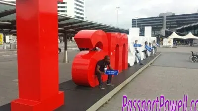 A traveller beside the large Amsterdam lettering