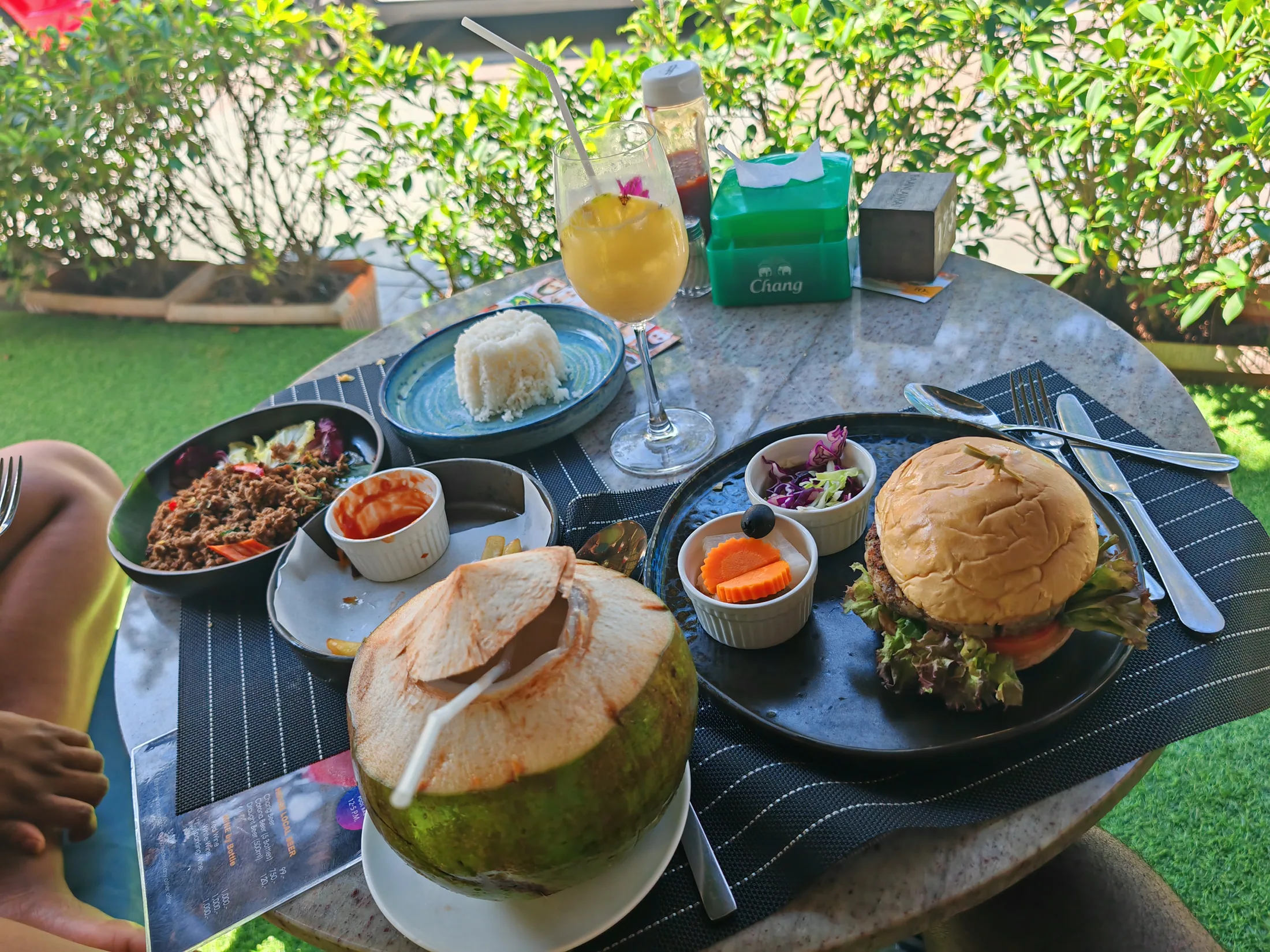 A meal and fresh coconuts at an outdoor table in Phuket
