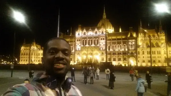 A traveller in front of Budapest’s illuminated Parliament