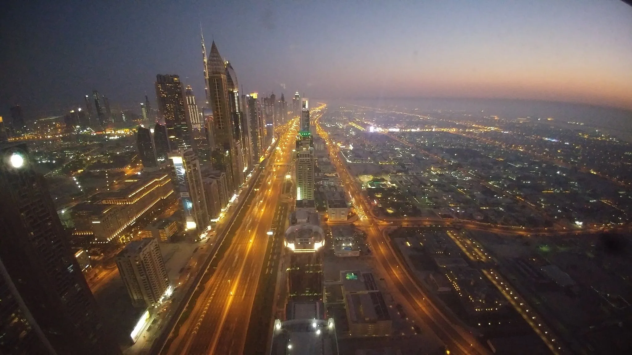 Dubai towers and an illuminated boulevard at dusk