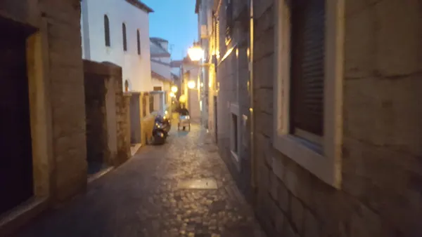 A narrow stone lane illuminated in the evening