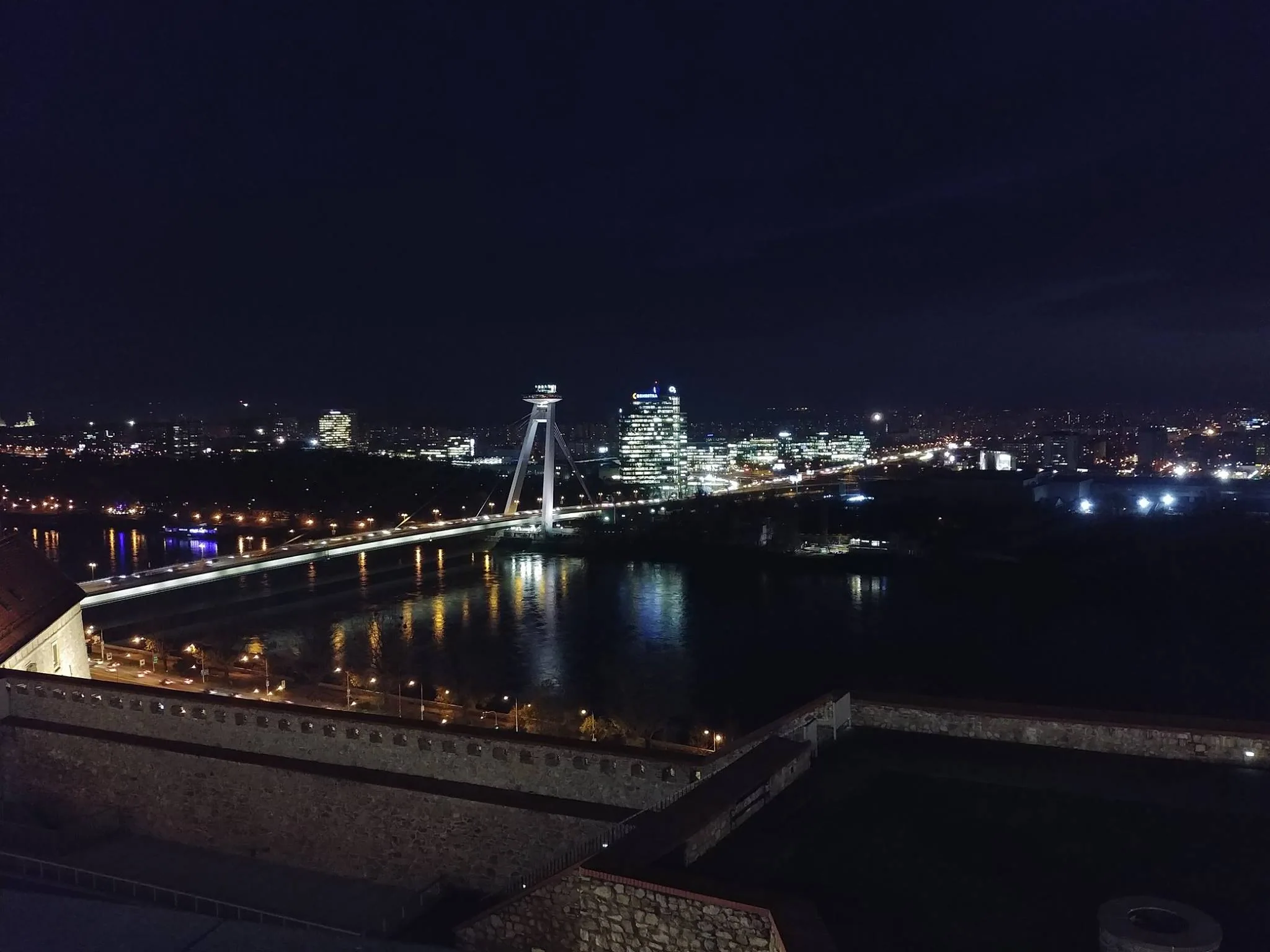 A brightly lit bridge spanning the Danube at night
