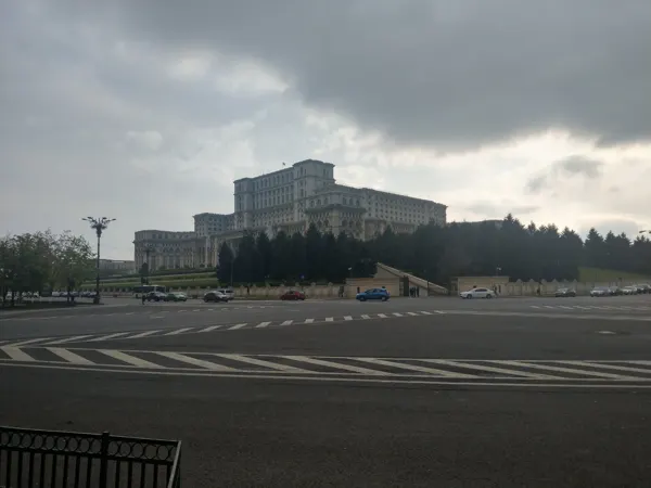The Palace of Parliament beneath a dramatic cloudy sky