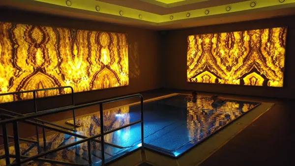 An indoor pool reflected beneath patterned golden panels