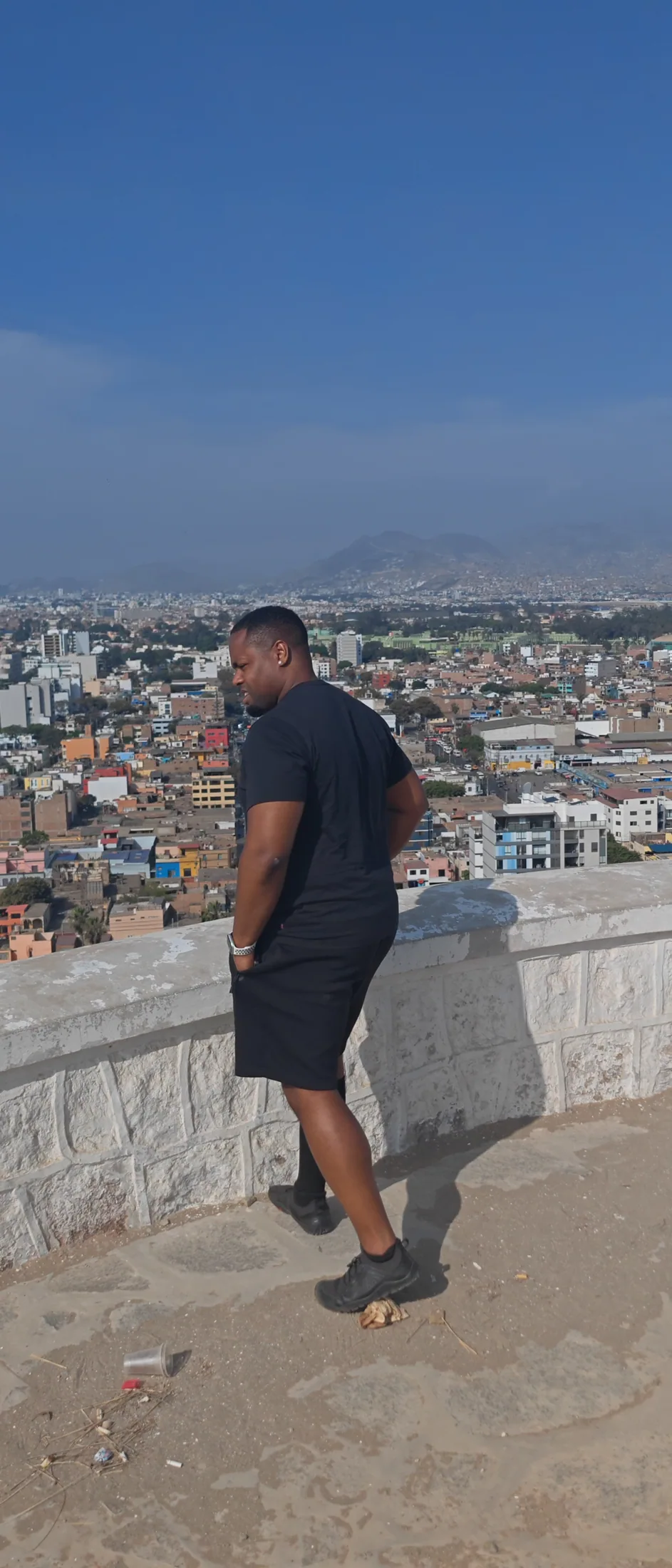 A traveller overlooking Lima from a hilltop
