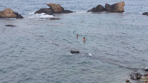 Rocky outcrops and swimmers along the Crete coast