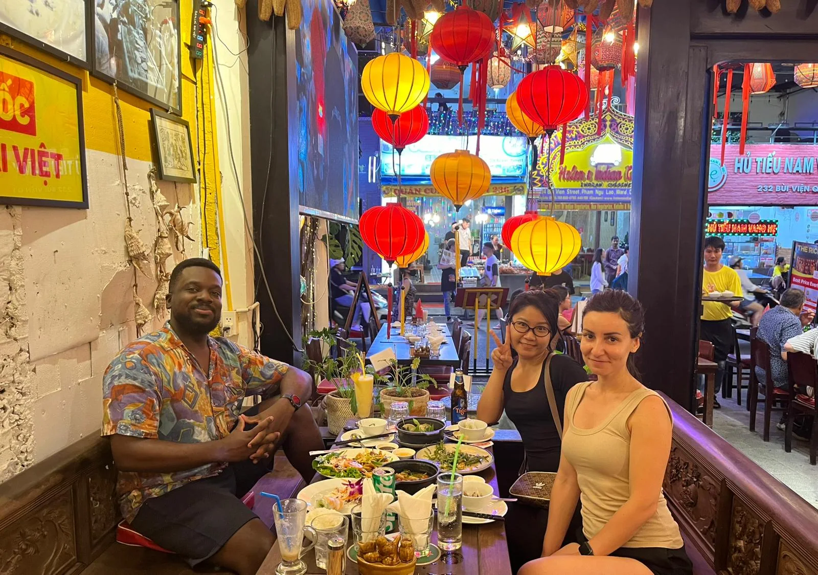 Travellers sharing dinner beneath lanterns in Ho Chi Minh City
