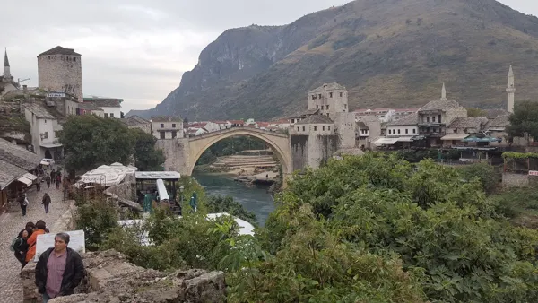 Mostar’s Old Bridge spanning the river below a mountain ridge