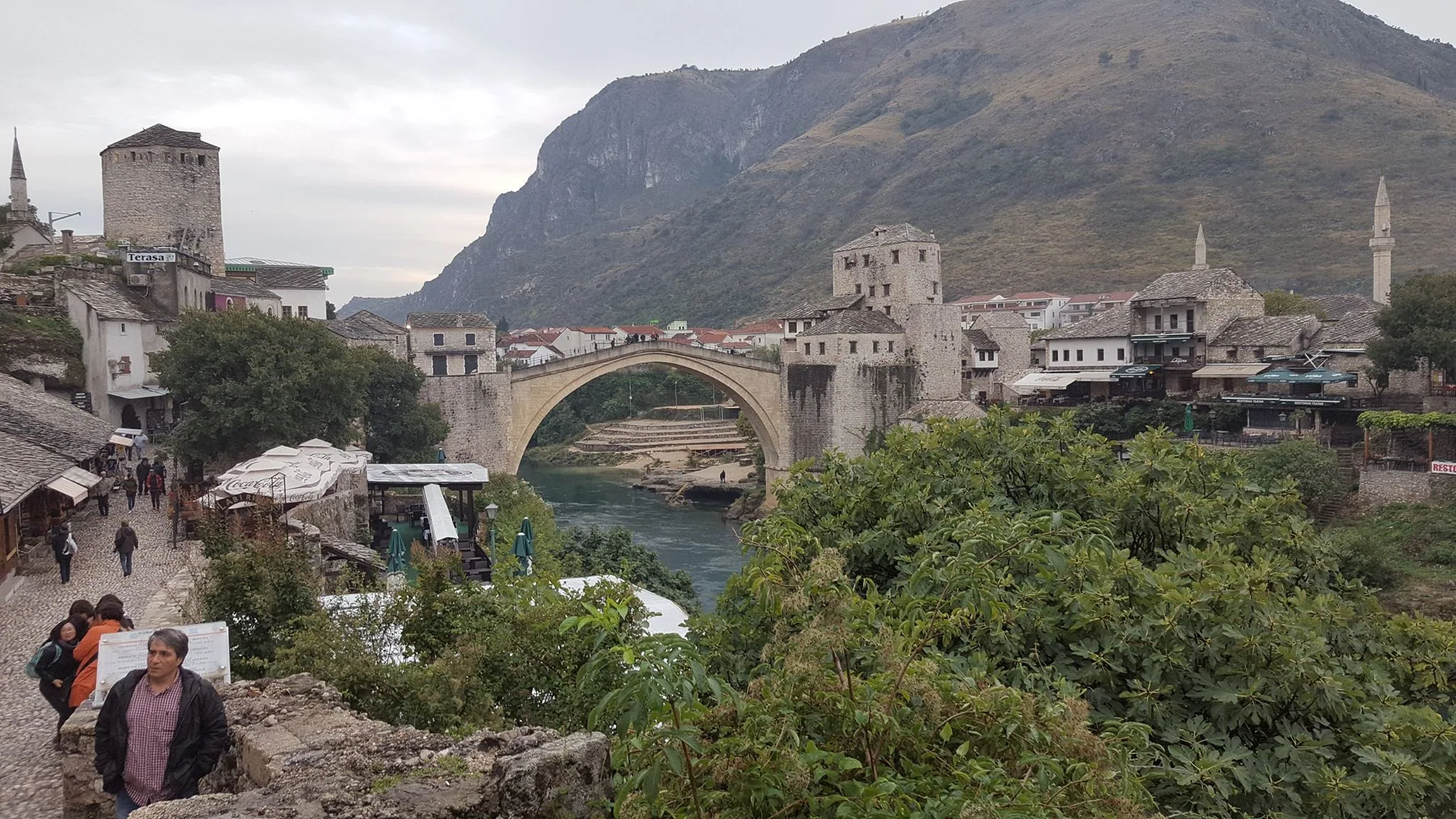 Mostar’s Old Bridge spanning the river below a mountain ridge
