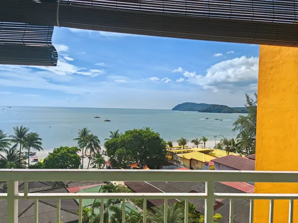 A balcony view over trees, beach and sea in Langkawi