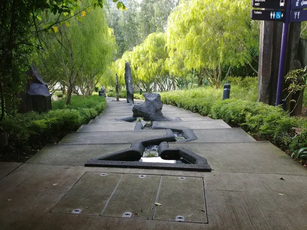 A shaded garden path beneath hanging green branches
