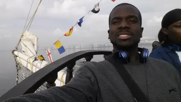 A traveller on a boat beneath small coloured flags