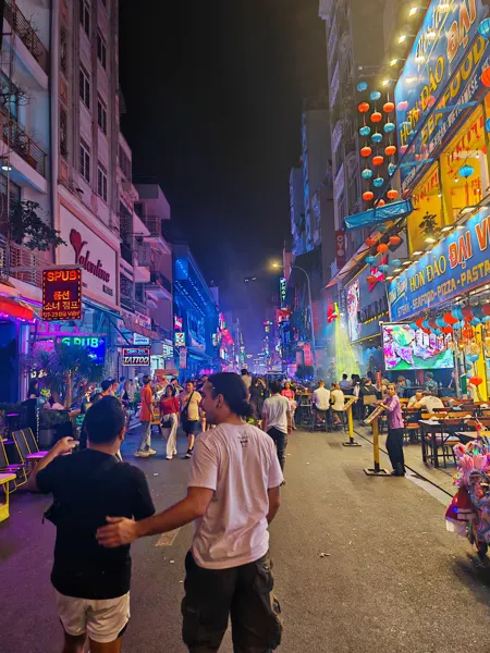 Colourful signs over a busy Ho Chi Minh City street at night