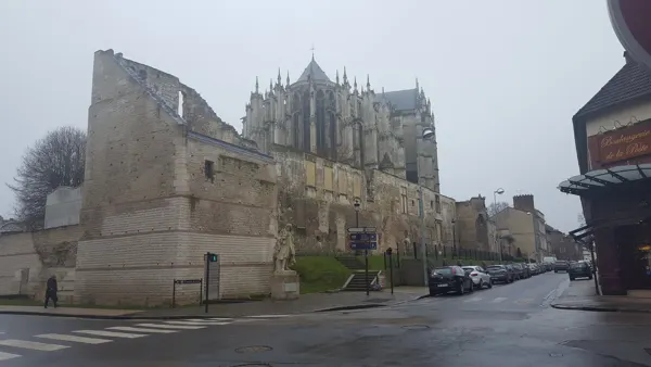 Historic stone walls and the cathedral rising above a Beauvais street