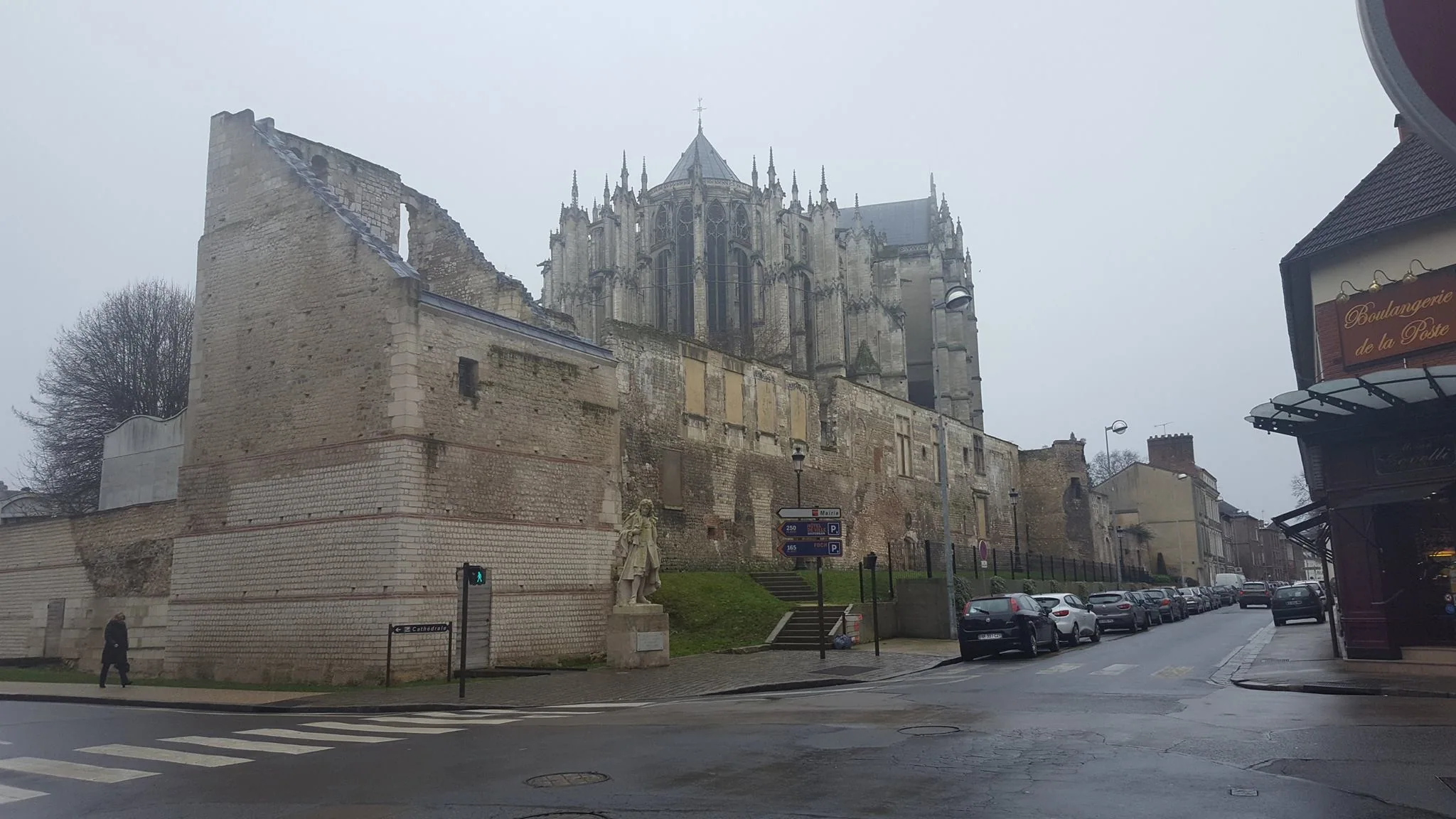 Historic stone walls and the cathedral rising above a Beauvais street