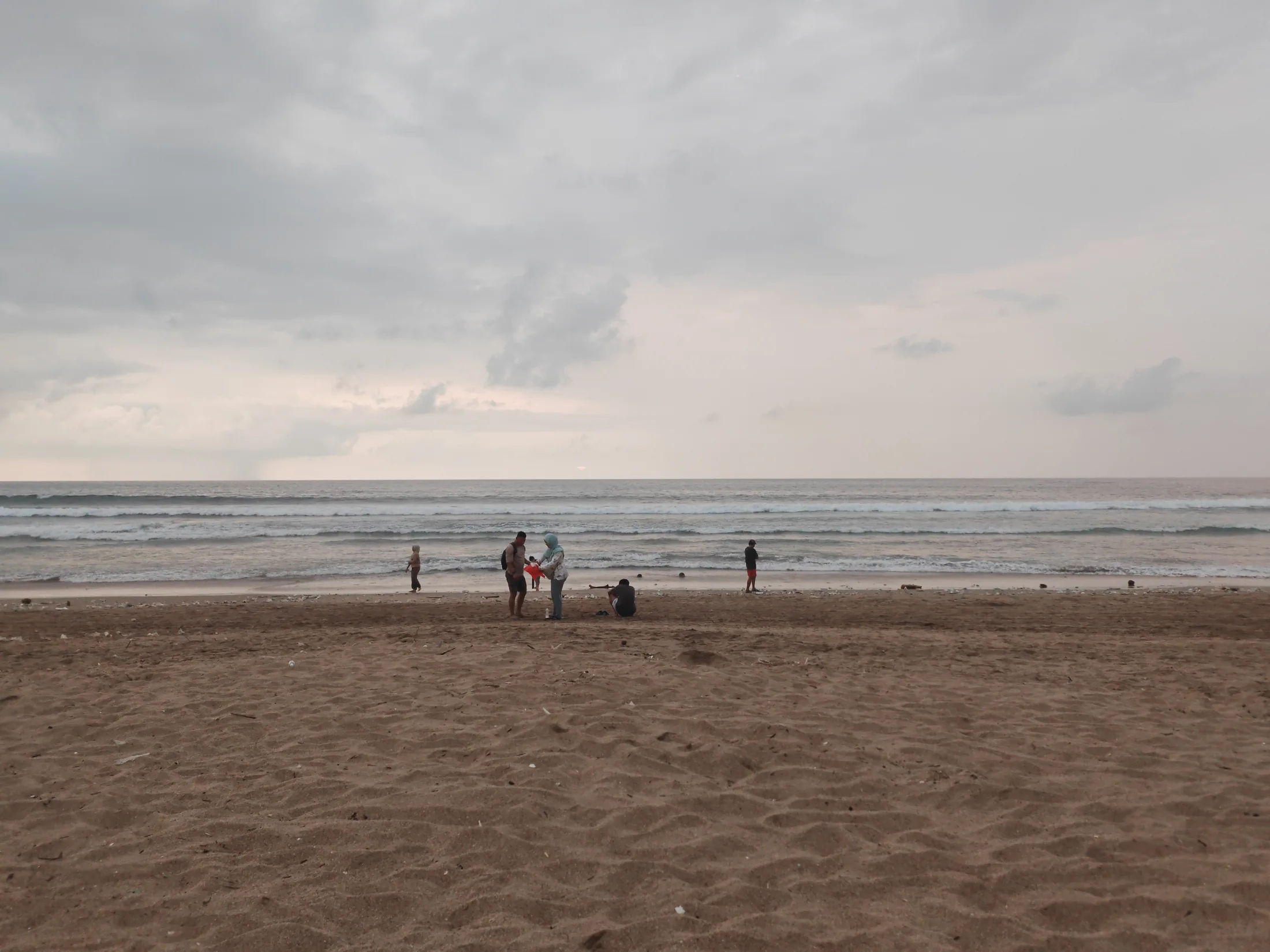 An overcast afternoon on a broad beach in Bali