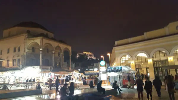 A busy Athens square illuminated after dark