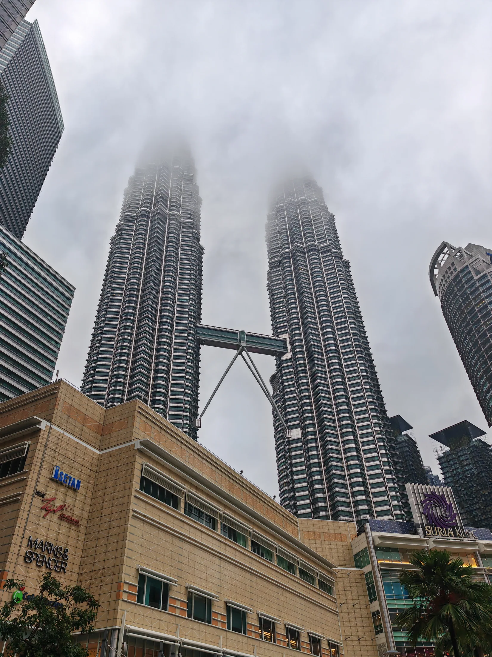 The Petronas Towers rising into low cloud in Kuala Lumpur