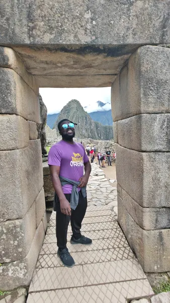 A traveller framed by a stone doorway at Machu Picchu