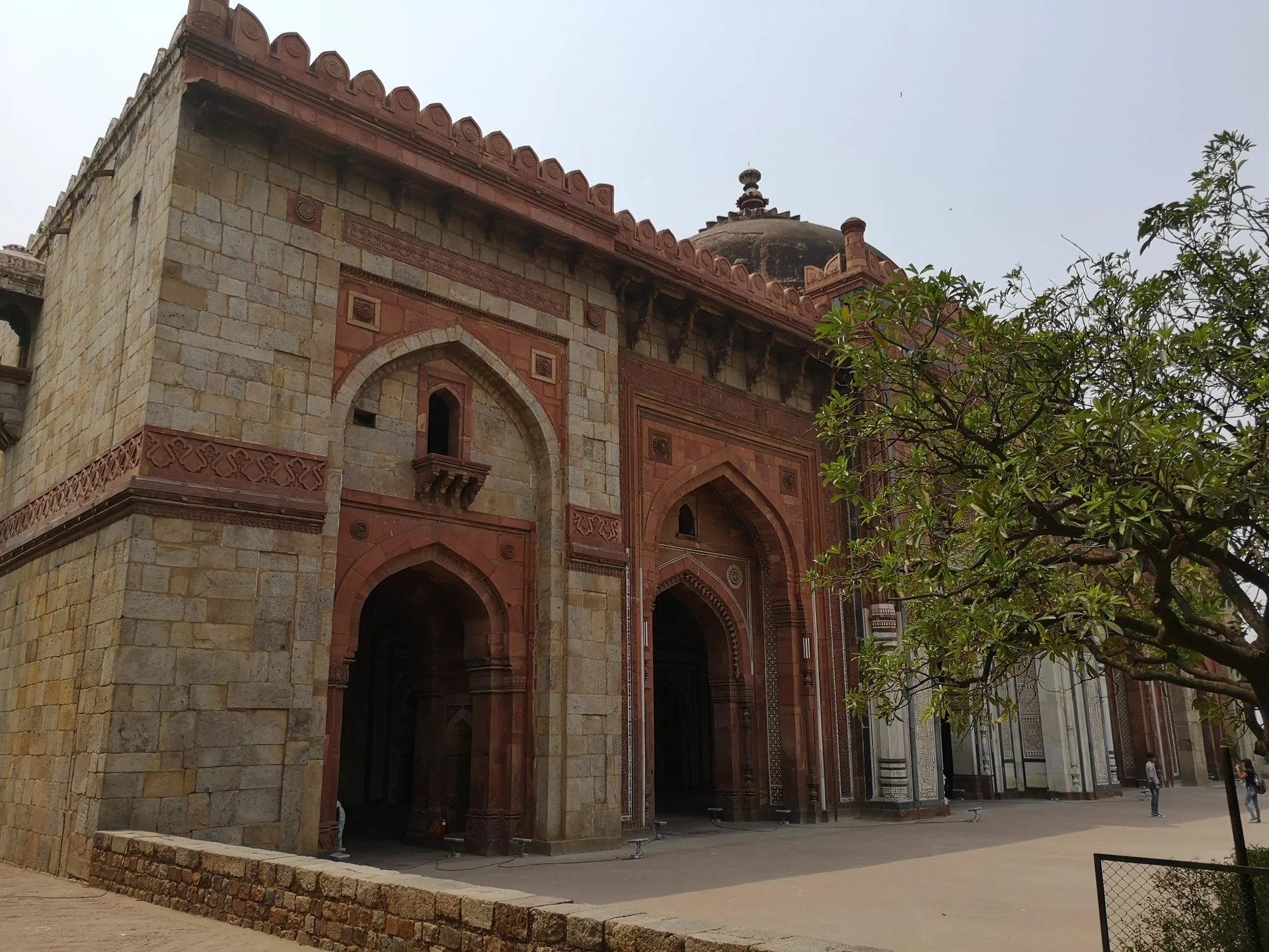 An ornate stone gateway beside a shaded path