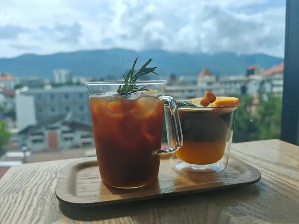 Two iced drinks with a view across Chiang Mai towards the mountains