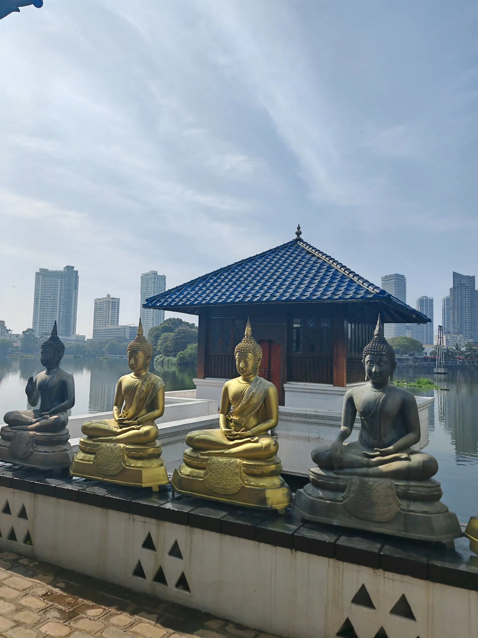 Buddha figures and a pavilion beside a lake in Colombo